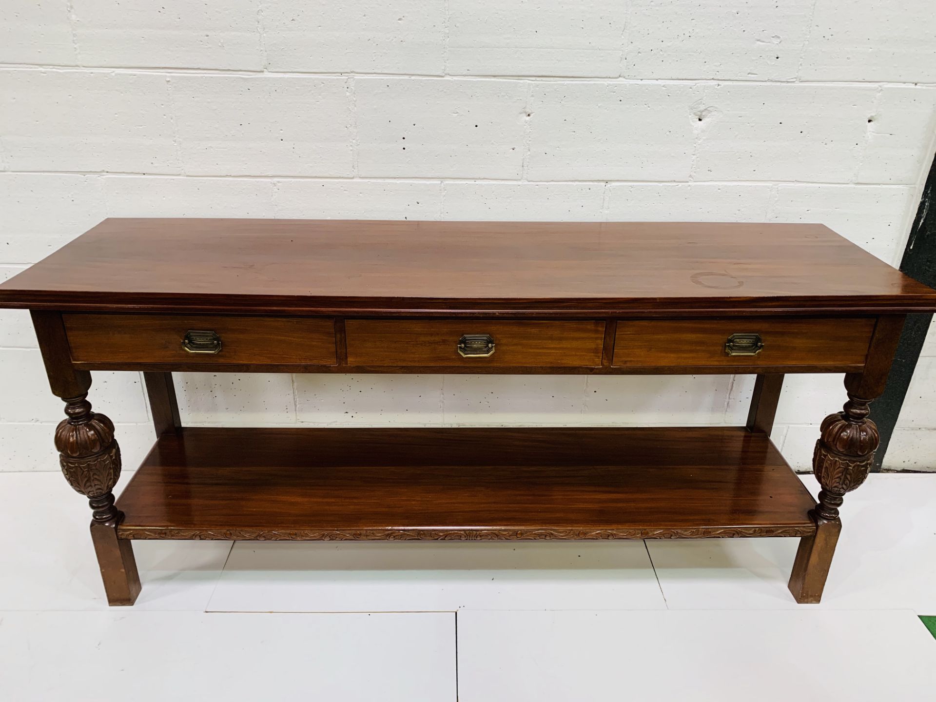 Mahogany sideboard with three frieze drawers over display shelf.