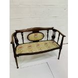 Edwardian inlaid mahogany upholstered salon settee with ornate splats.