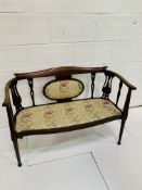 Edwardian inlaid mahogany upholstered salon settee with ornate splats.