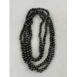 Large single string of individually knotted Tahitian black pearls.