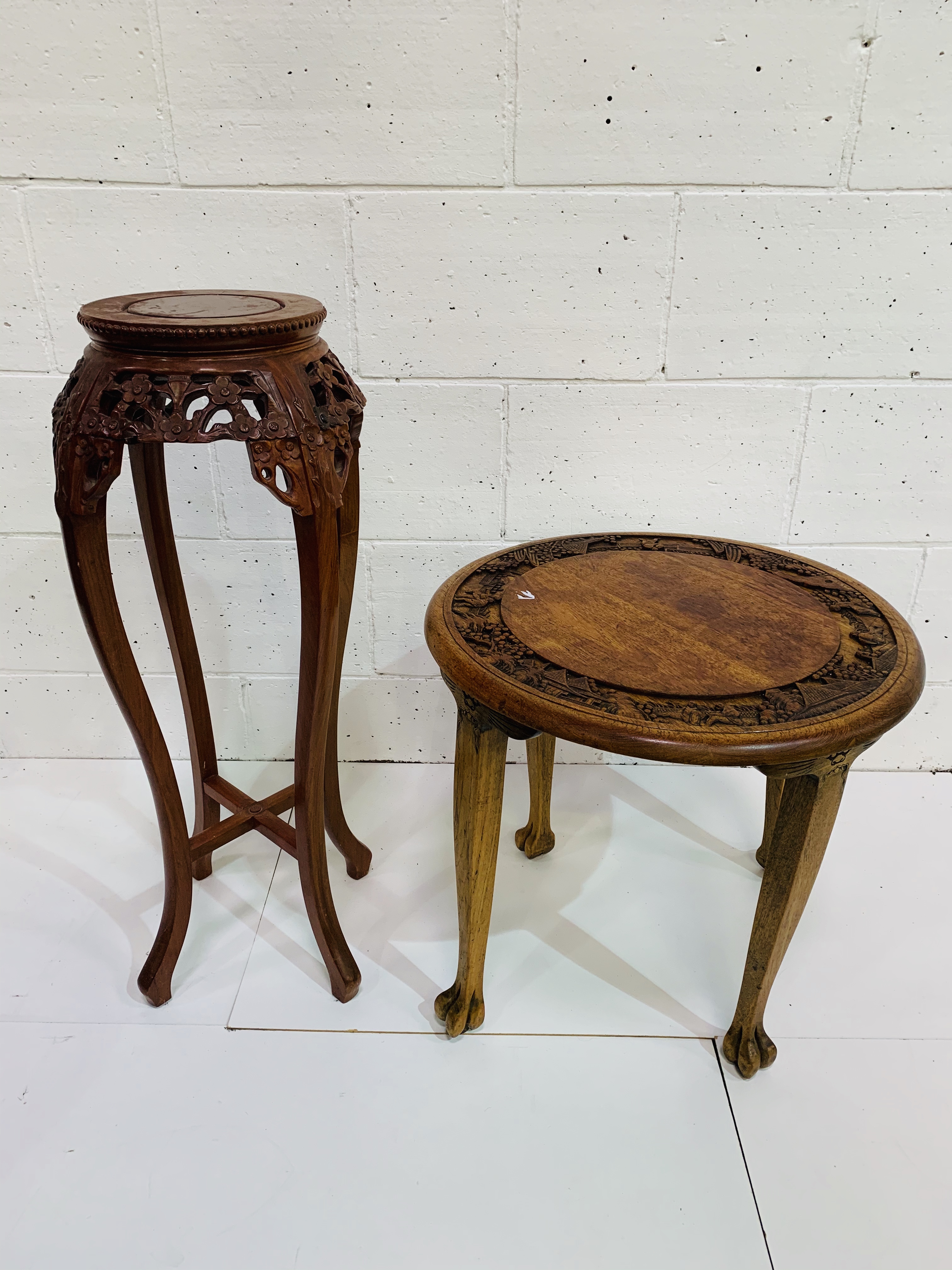 A circular carved oak table on four legs, and a hardwood pot stand.