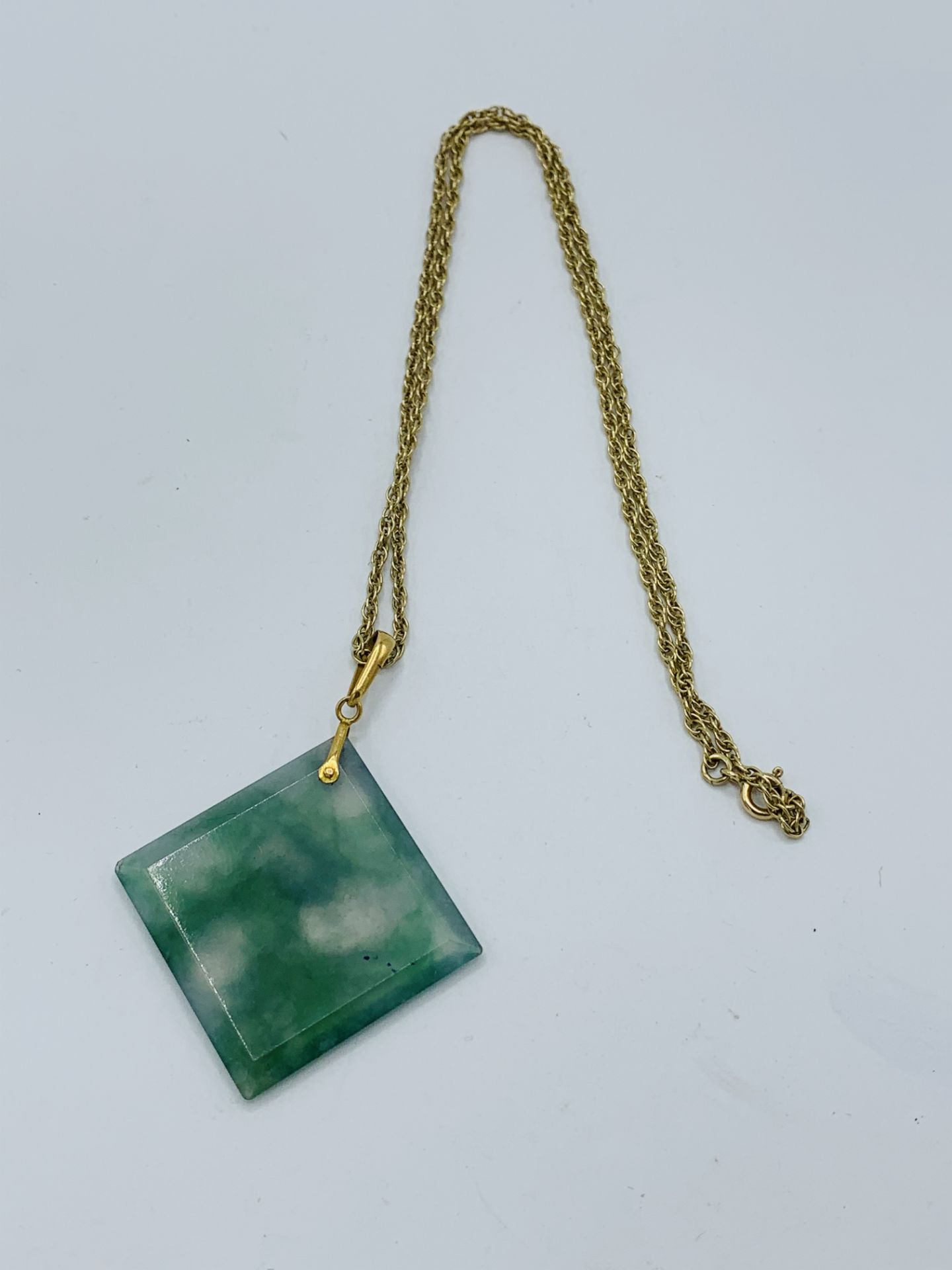 Square cut pendant of moss agate with gold bale and 9ct gold chain.