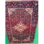 Red ground hand knotted carpet.