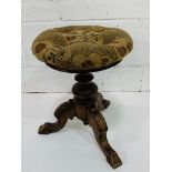 Late 19th century rise and fall padded piano stool with carved acanthus leaves.