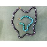 A turquoise bead bracelet and a black pearl necklace.