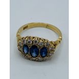 Three stone sapphire and diamond oval ring.