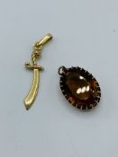 9ct gold cutlass pendant, 1.9gms and Yellow stone pendant in yellow metal surround.