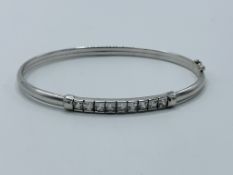 9ct white gold bangle with safety catch set with clear stones.