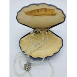 Three string glass bead necklace in shell shaped box.