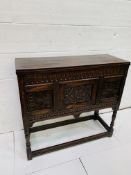 Carved oak cabinet with lifting lid, two doors to cupboard below, on carved stretchers.