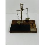 Set of small chemist's scales on stand complete with brass weights.