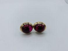 18ct yellow and white gold cuff links each set with with a single large ruby cabochon