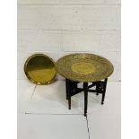 Indian brass top table on carved collapsable six legged stand, together with a brass tray.