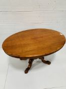 Mahogany oval tilt top table on carved pedestal to four feet.