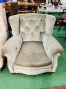 A large green upholstered Victorian armchair on casters. 100 x 100 x 88cms.