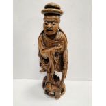 A wooden carved oriental figurine of a monk.