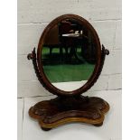 Mahogany framed oval toilet mirror on twisted support.