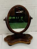 Mahogany framed oval toilet mirror on twisted support.