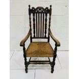 Oak framed open arm chair with carved rail over rail back, cane seat (needs recaning).