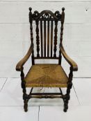 Oak framed open arm chair with carved rail over rail back, cane seat (needs recaning).