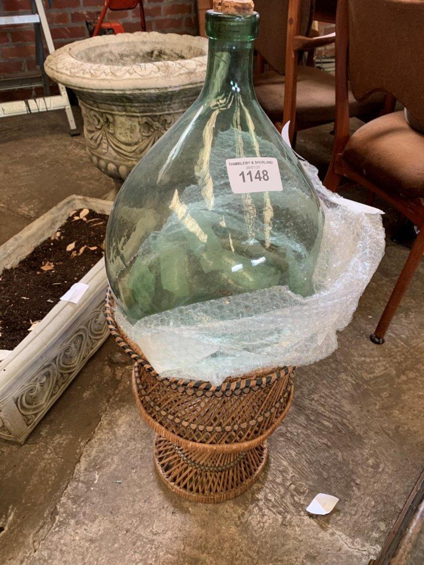 Glass bottle on wicker stand.