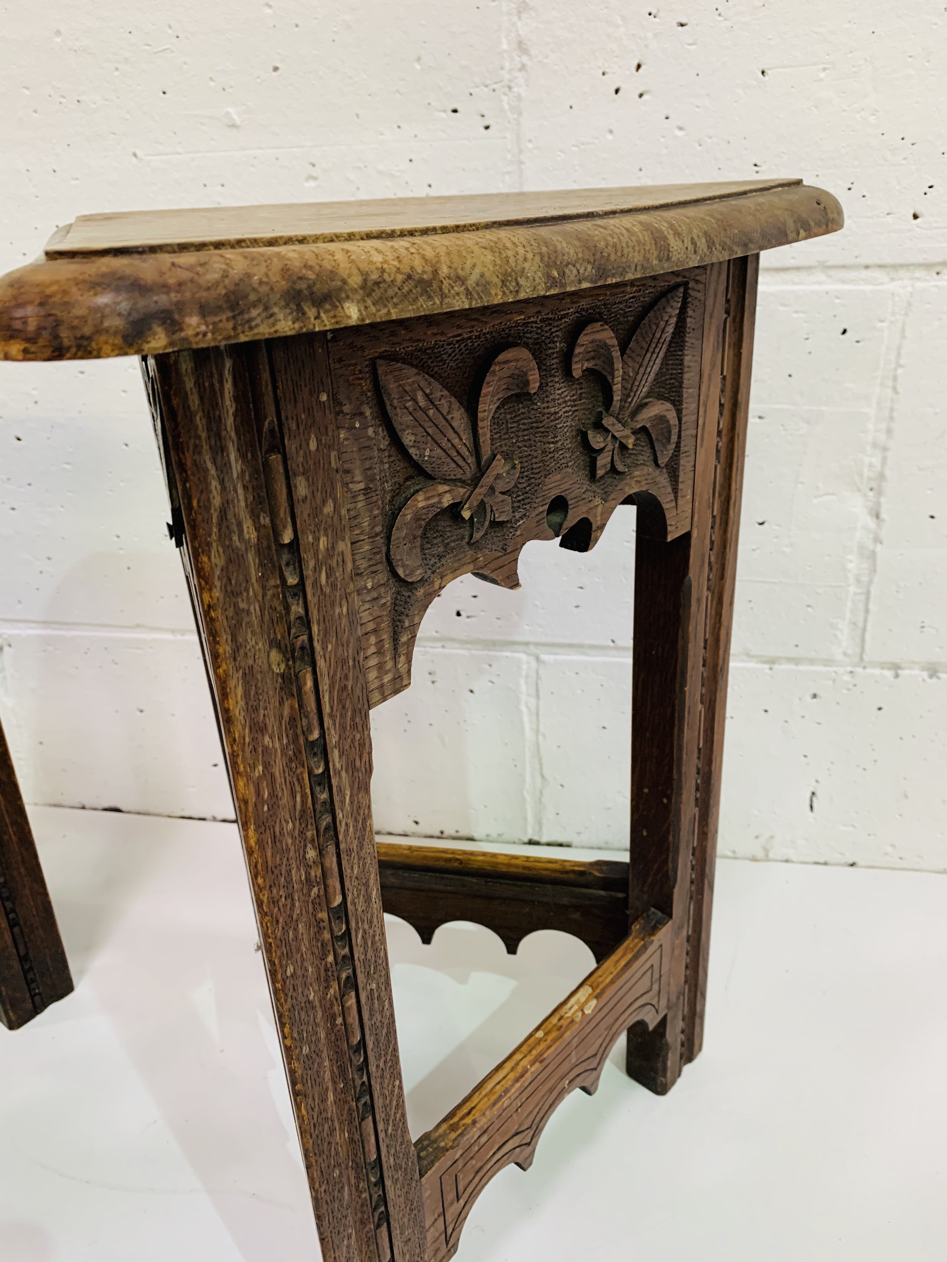 Pair of oak Arts and Crafts triangular stools with lifting lids, carved with fleurs-de-lys. - Image 2 of 4