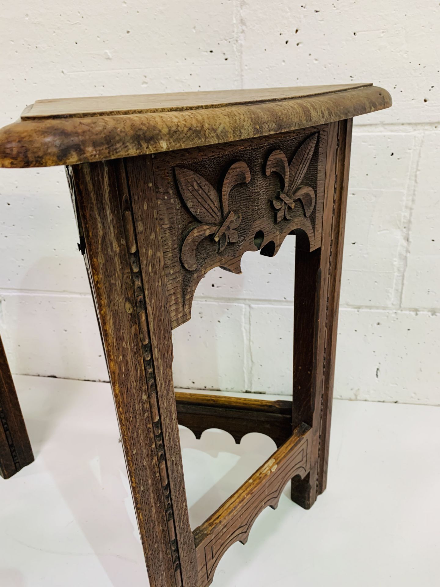 Pair of oak Arts and Crafts triangular stools with lifting lids, carved with fleurs-de-lys. - Image 2 of 4