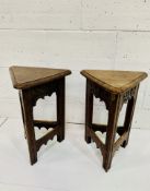 Pair of oak Arts and Crafts triangular stools with lifting lids, carved with fleurs-de-lys.