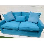 Two seat sofa by "Sofa Workshop" upholstered in turquoise cotton loose covers, with matching cushion