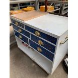 Chest of drawers on casters with a cork board.