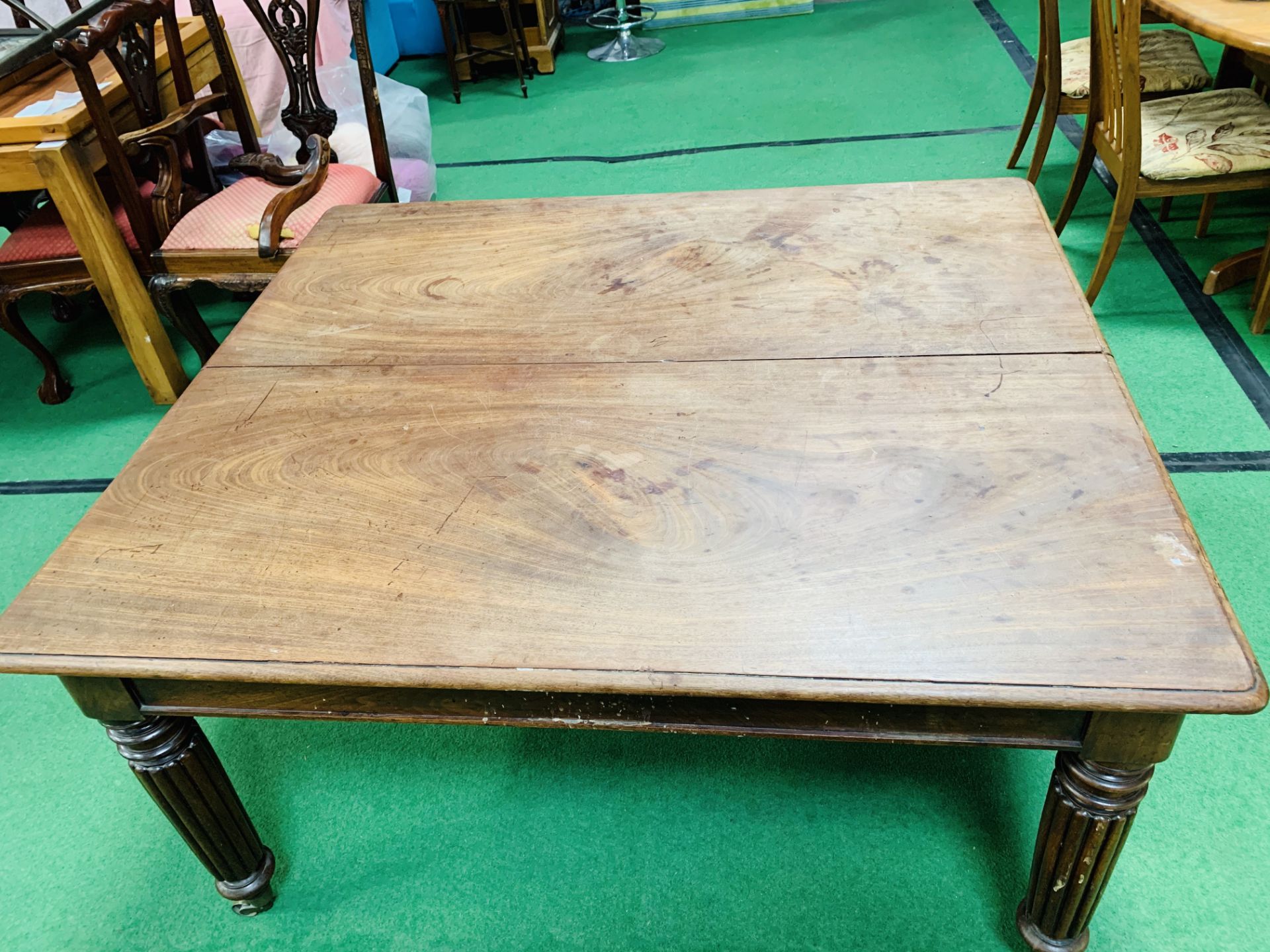 Victorian mahogany extendable dining table on turned reeded legs on brass casters