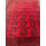 Wool pile red ground carpet rug made in Afghanistan.