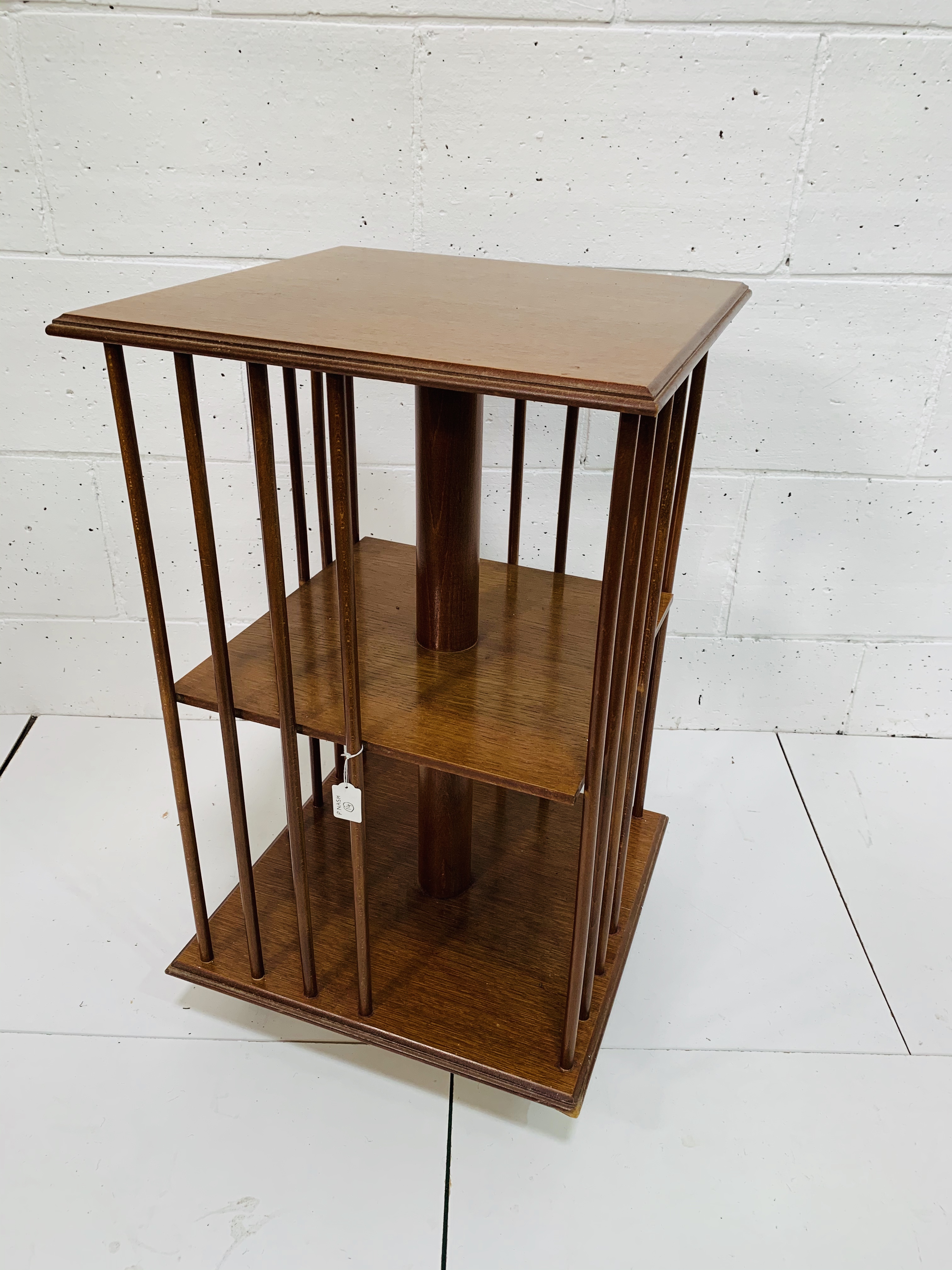 Mahogany revolving two tier bookcase on casters.