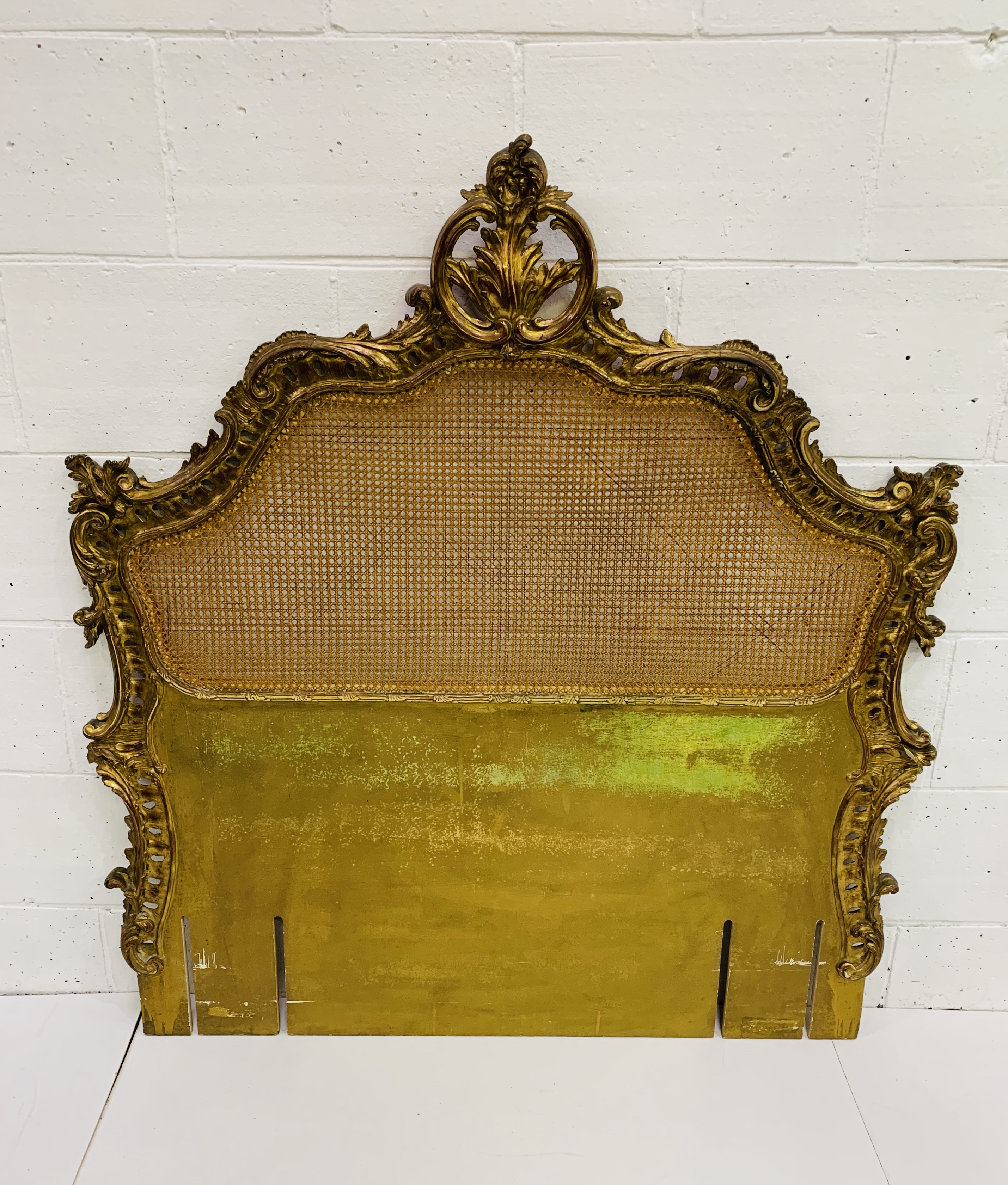 French headboard with cane panel and ornate gilt surround. 130 x 143cms.