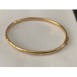 9ct yellow gold bangle with engraved design to top, 6gms.