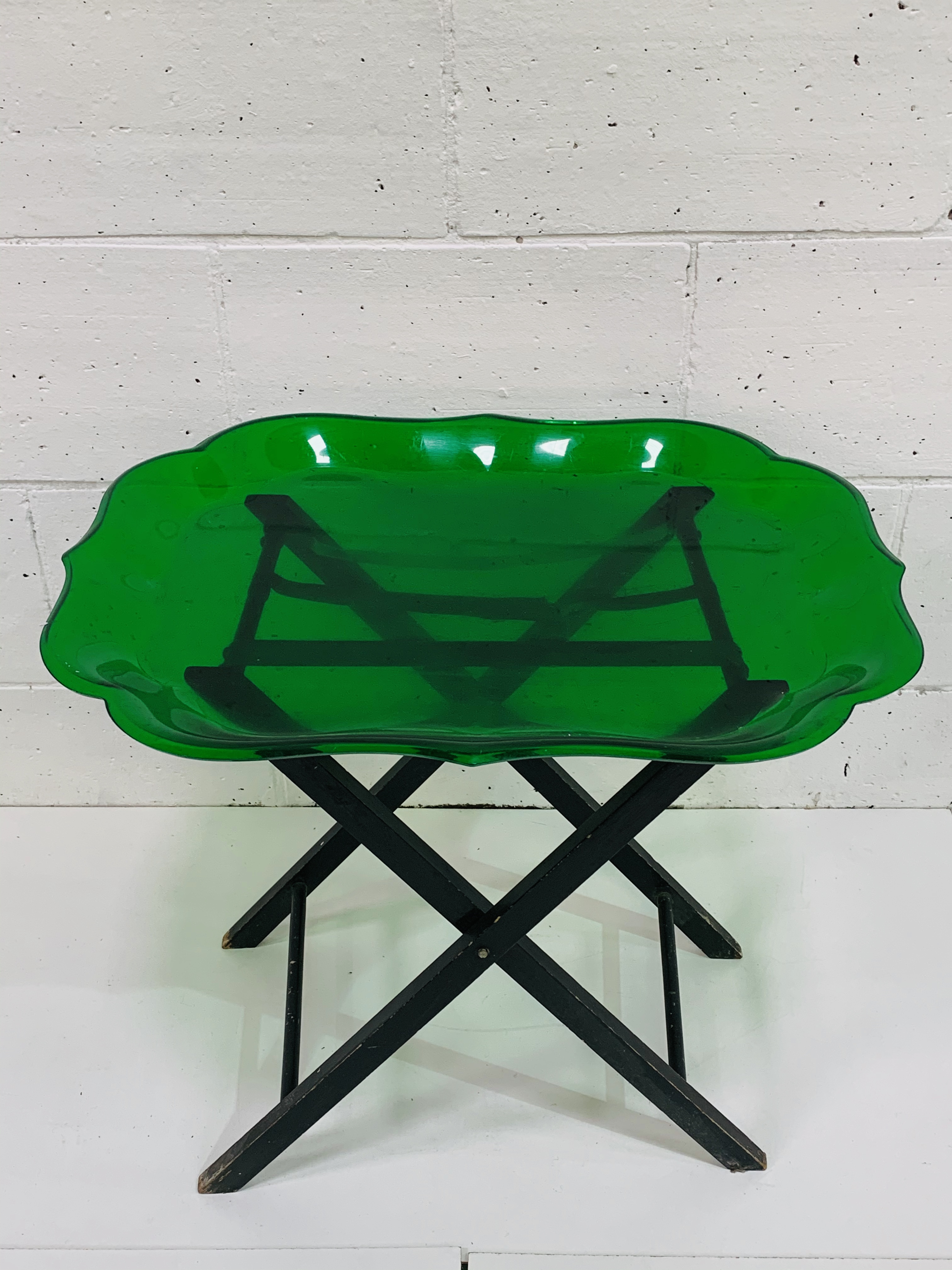 Lucite bottle green tray with scalloped edges, on collapsable stand.