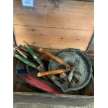 A pine box containing various garden hand tools.