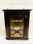 Oak corner wall cabinet with two shaped fronted shelves, glazing to door missing.