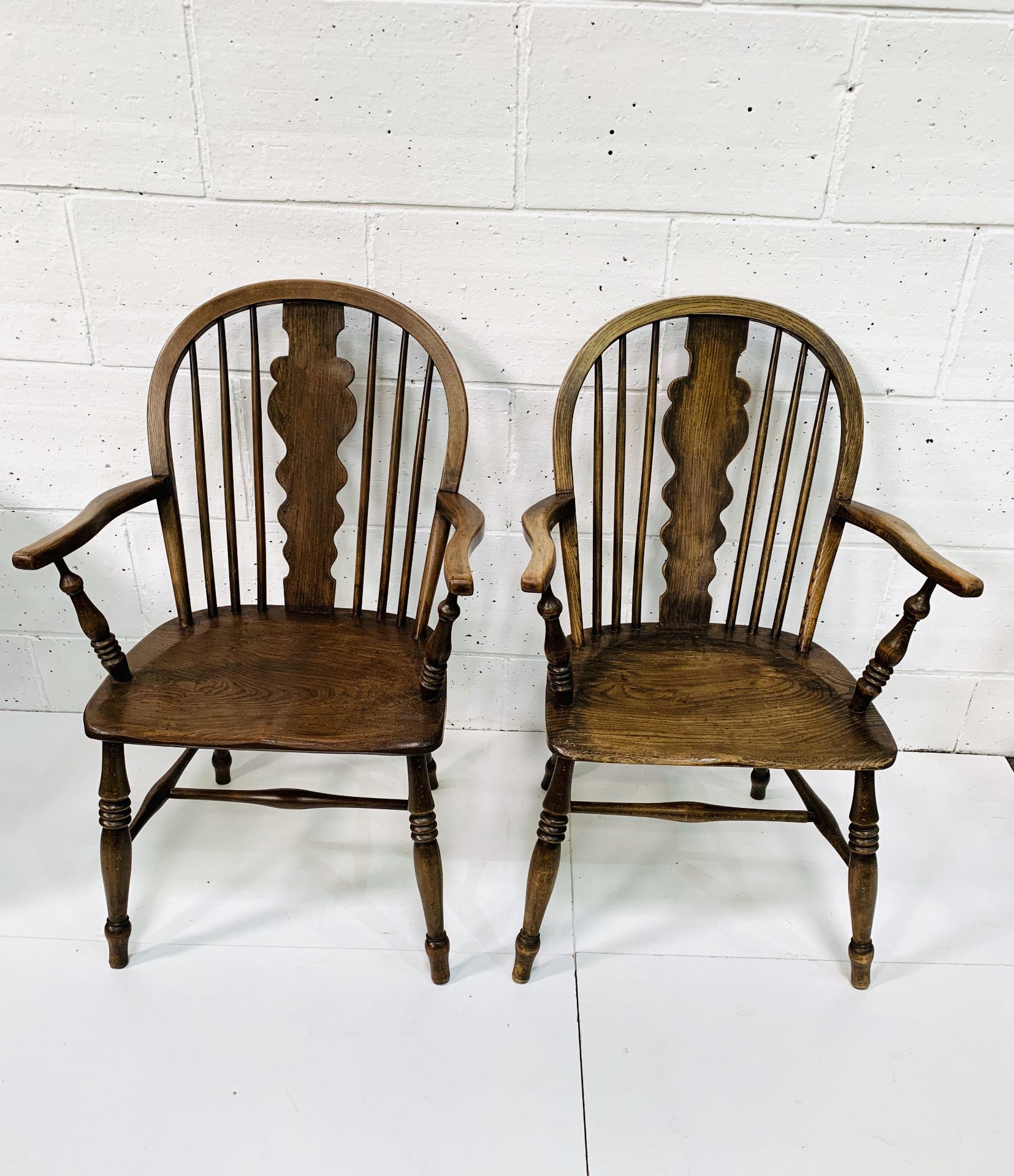 Two oak and elm Windsor style open armchairs with rail backs.