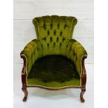 Drawing room chair upholstered in button back green upholstery.