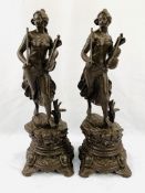 Two bronzed spelter female figurines as clock garnitures.