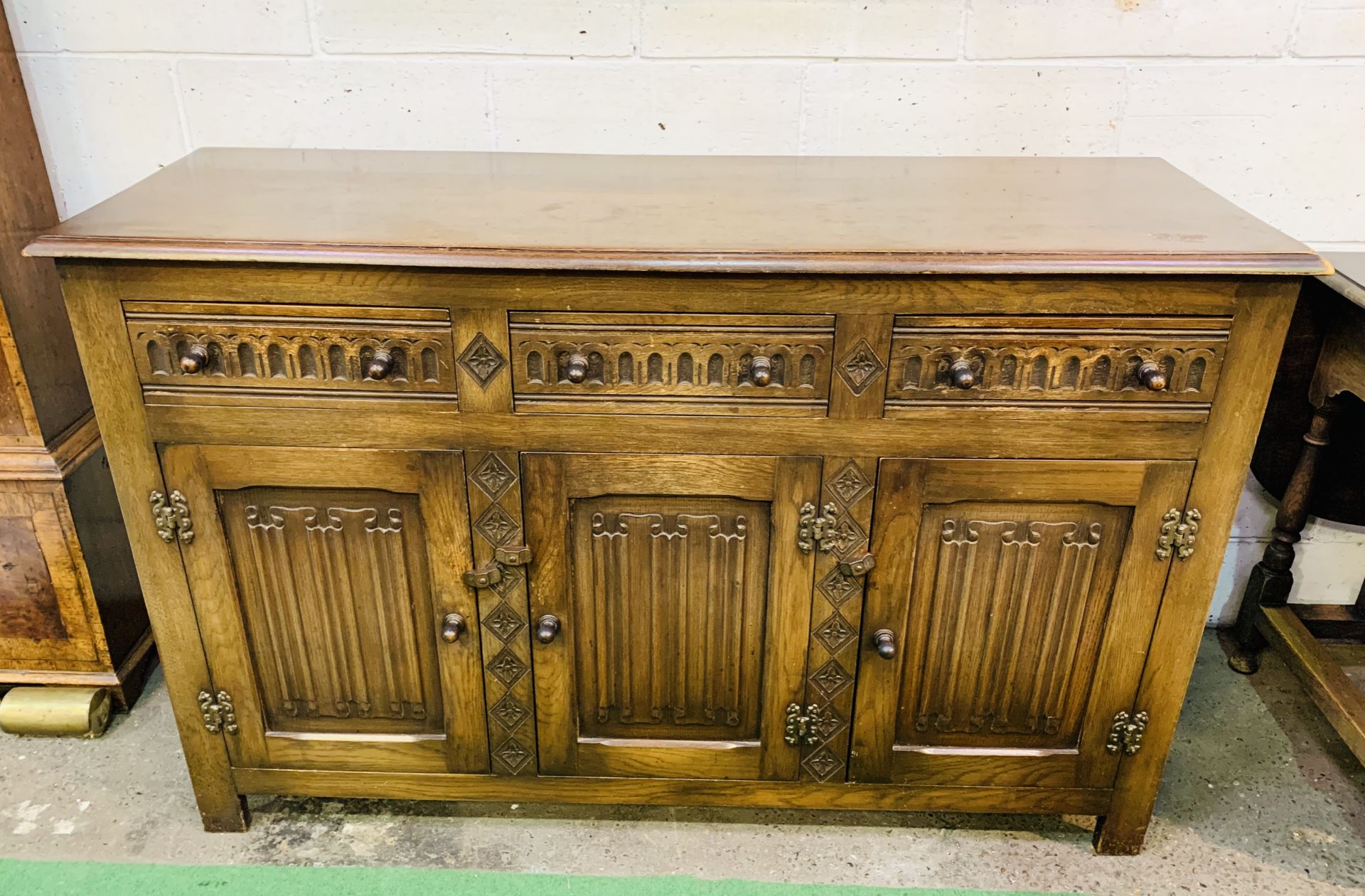 1930's oak sideboard with three frieze drawers over three cupboards.