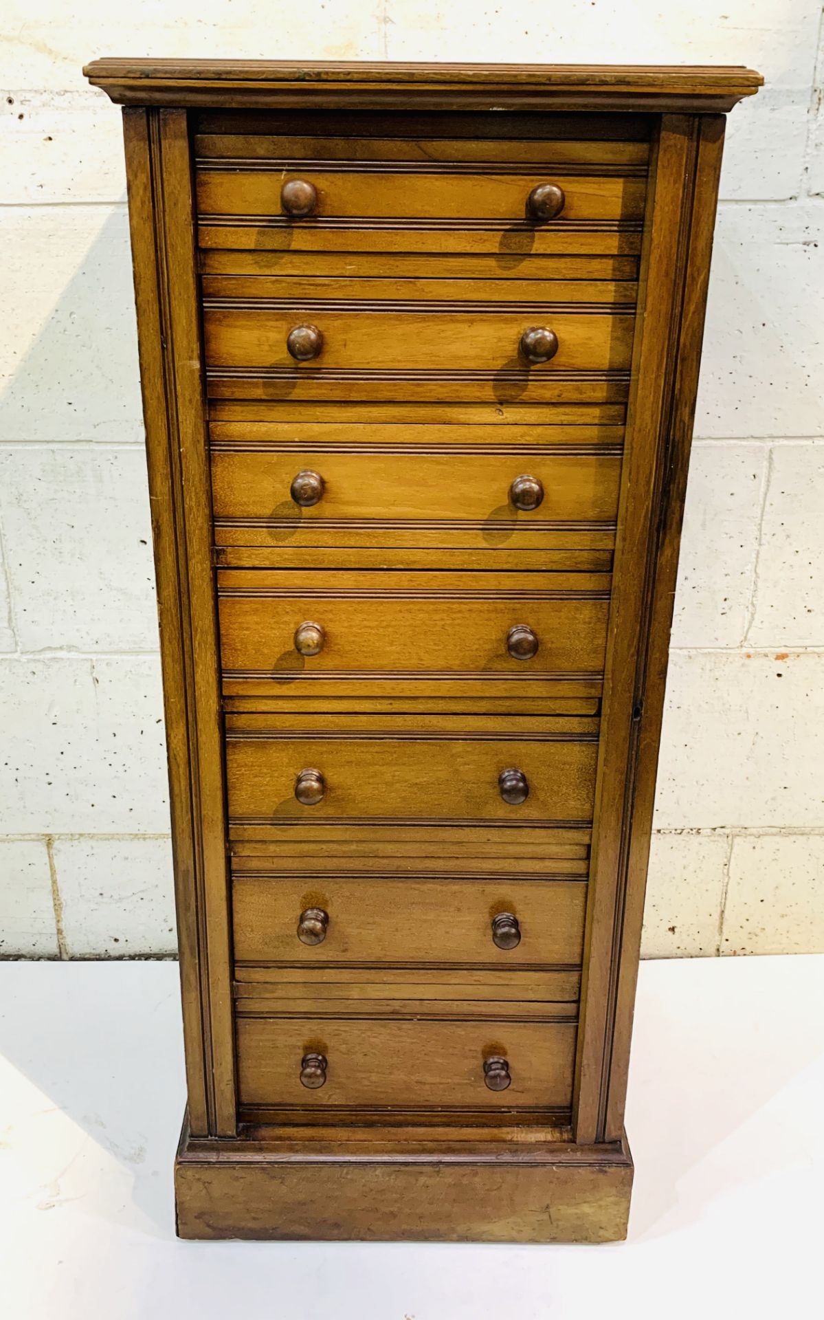 Mahogany Wellington chest of seven graduated drawers, complete with key.