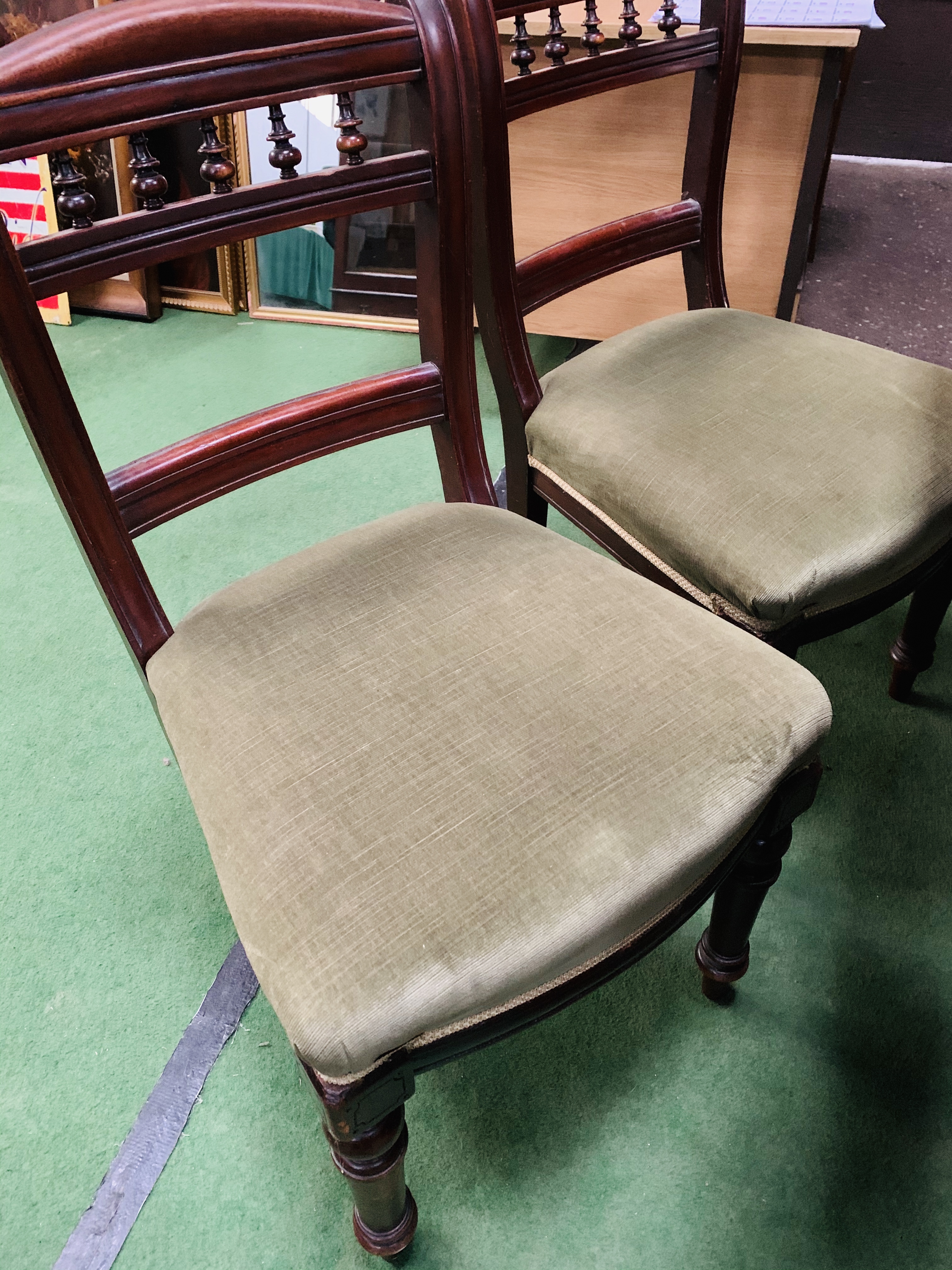 Four mahogany dining chairs with green upholstered seats.