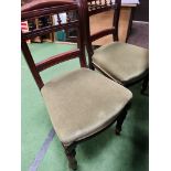 Four mahogany dining chairs with green upholstered seats.