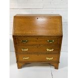 Small oak bureau with fitted interior, string inlay and brass handles, complete with key.