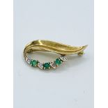 9ct diamond and emerald brooch in a leaf design, length 3cms.