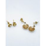 A pair of gold earrings together with a pair of gold and pearl earrings.