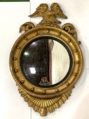 Regency circular convex glass wall mirror in a gilt frame, with eagle surmount.