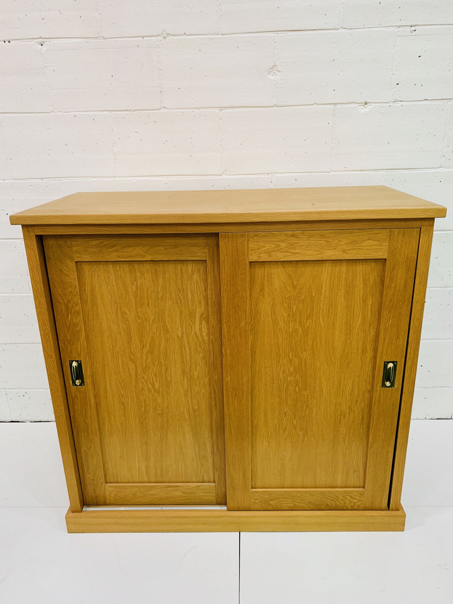Oak low wardrobe with two sliding doors.